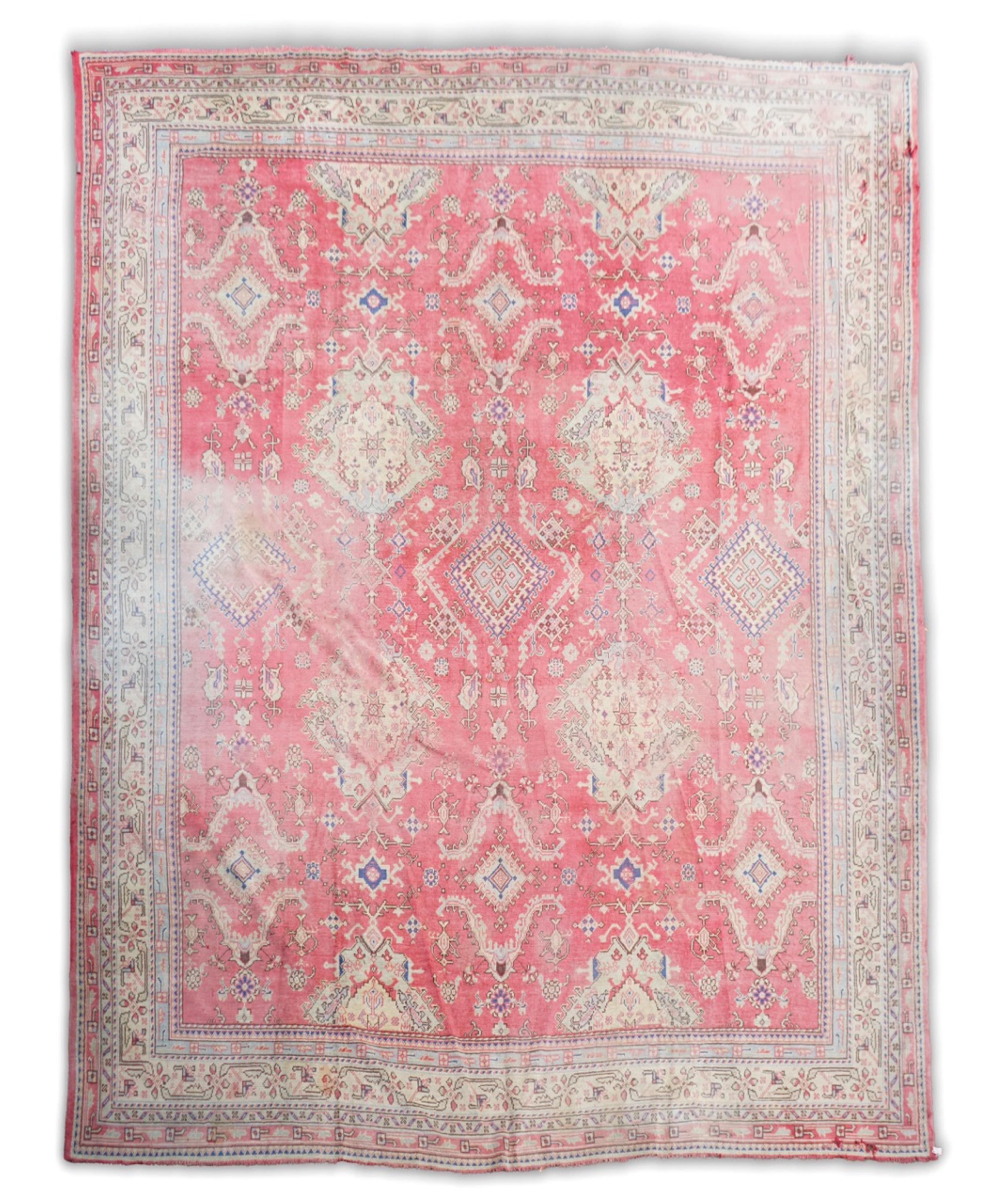 A large Turkish faded red ground carpet
